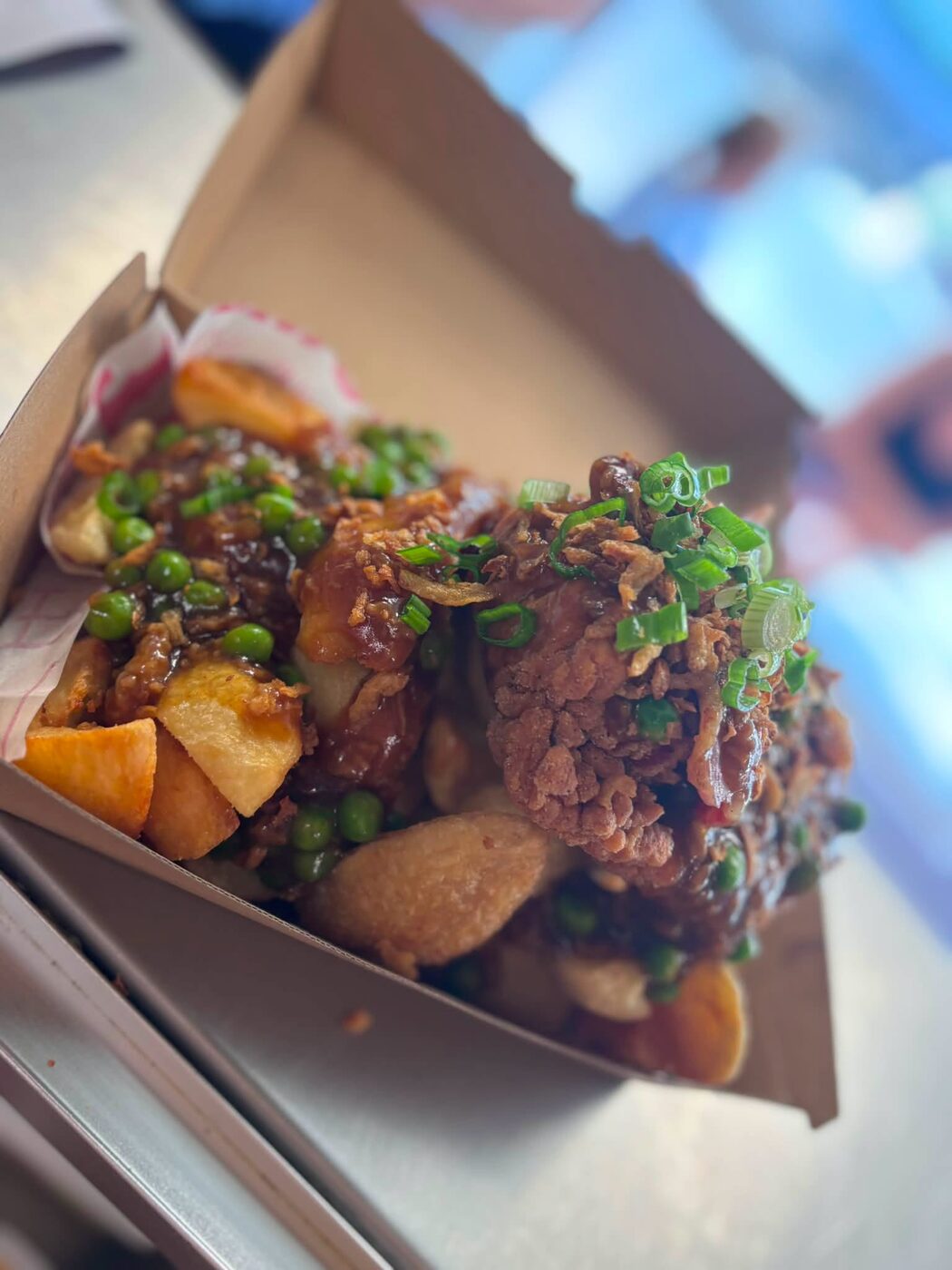 Curry chips with crispy chicken, peas, gravy and crispy onions