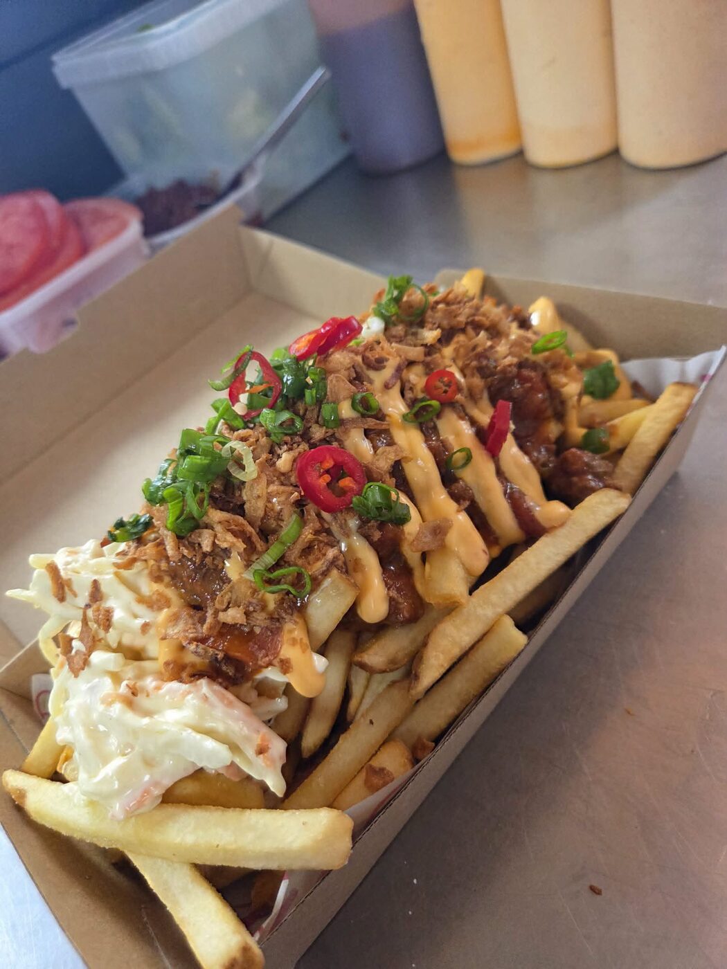 Loaded box of wings, chicken and popcorn bites with sauces and spring onion